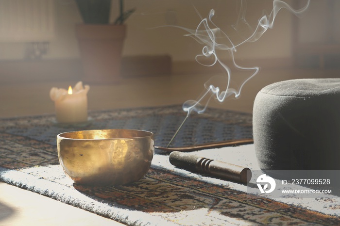 meditation room with singing bowl, incense stick, smoke, pillow and candle