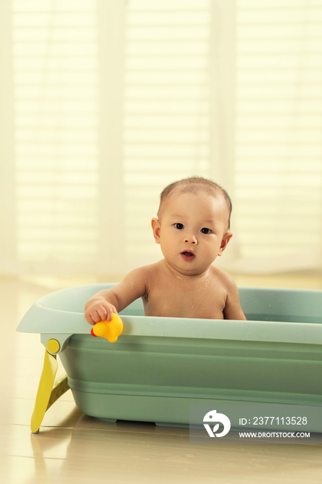 可爱宝宝坐在浴盆里洗澡