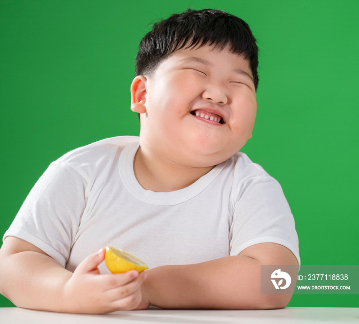 可爱的肥胖小男孩吃水果