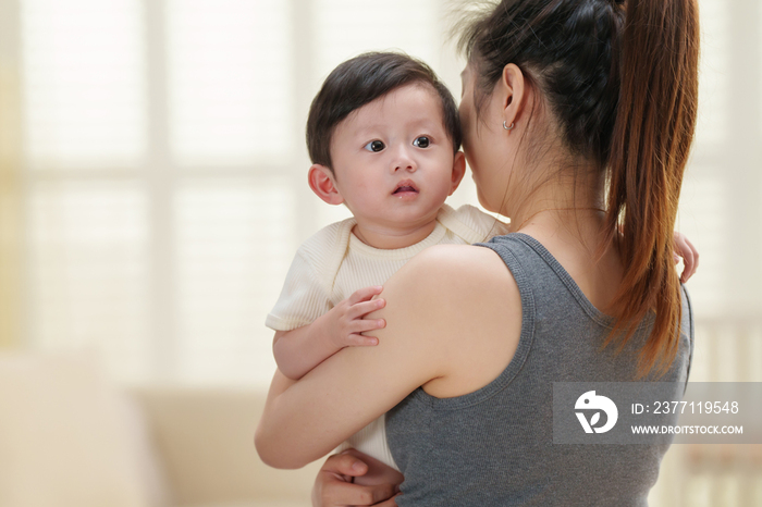 年轻妈妈抱着可爱的宝宝