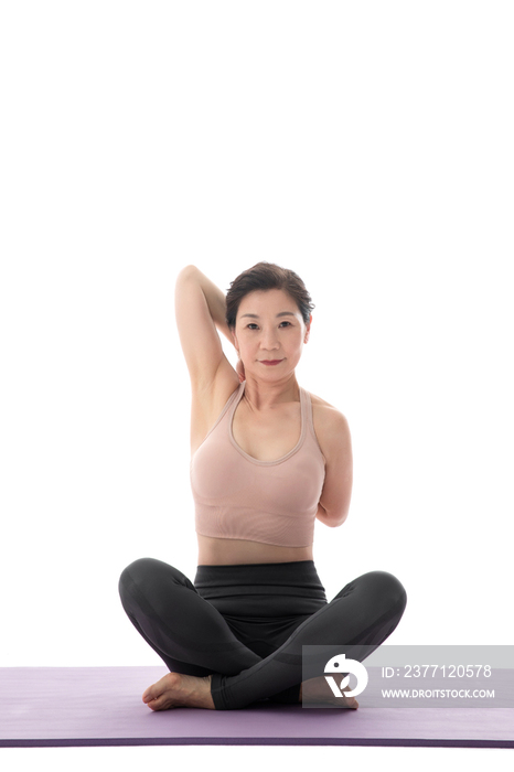盘着腿坐着练瑜伽的中年女士