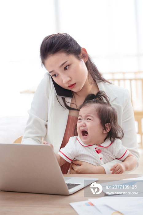 年轻妈妈抱着孩子使用电脑