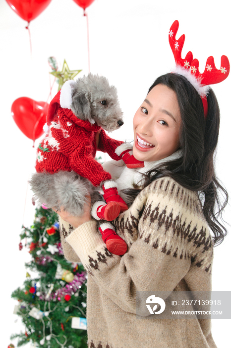 抱着宠物狗的青年女人过圣诞节