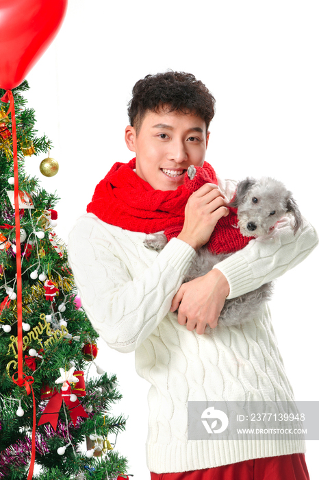 抱着宠物狗的青年男人过圣诞节