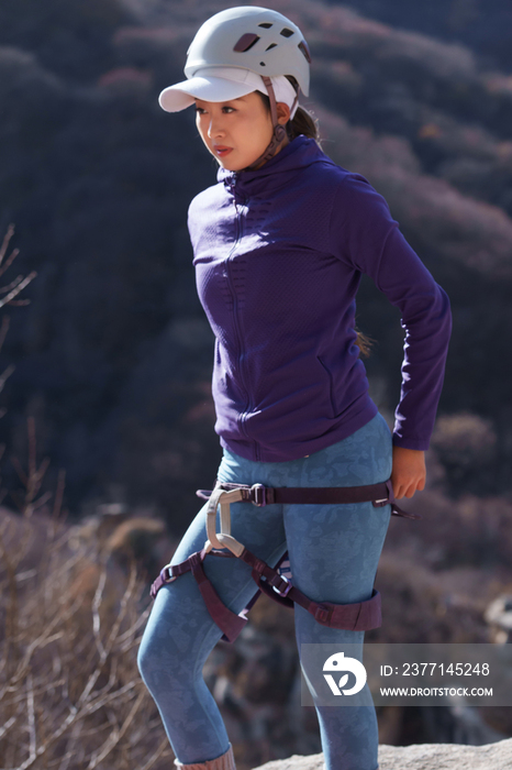 青年女性登山者准备攀岩装备