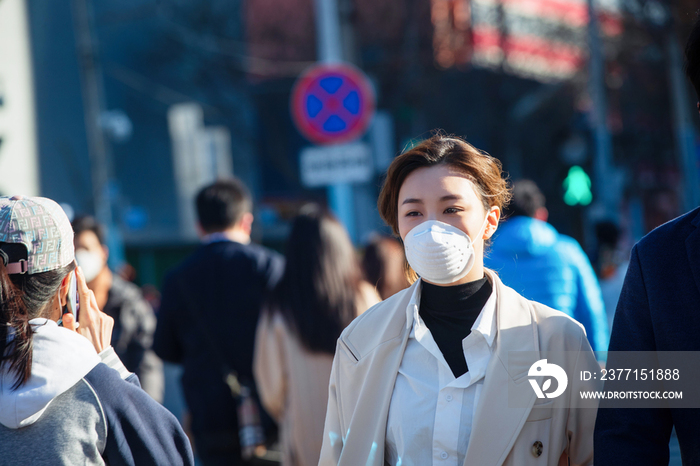 青年女人戴口罩在户外行走