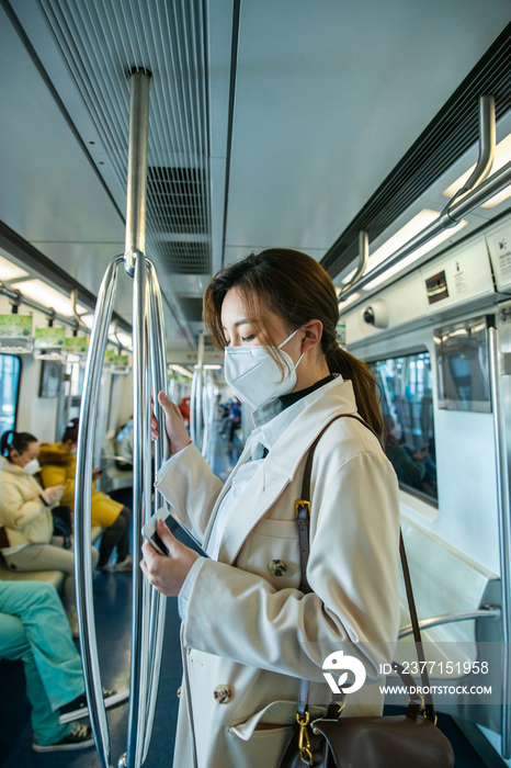 戴口罩的年轻女人乘坐地铁