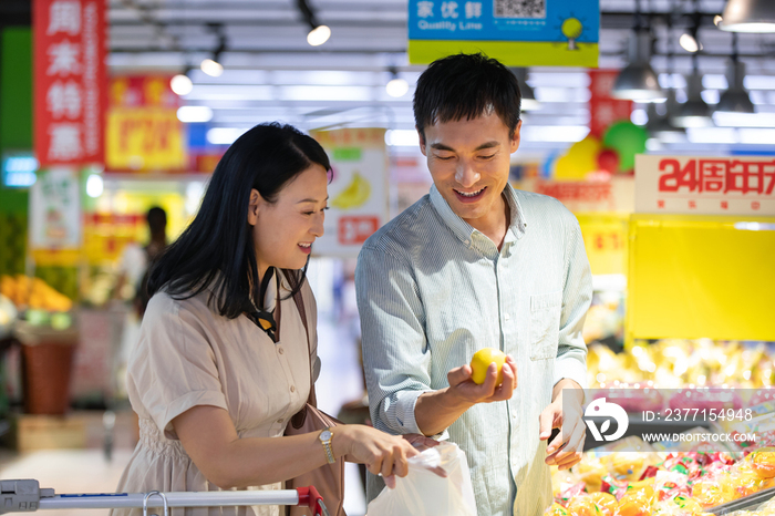 中年夫妇在超市挑选水果