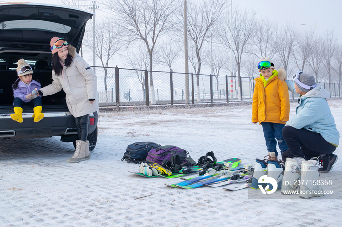 停车场内清点滑雪装备的一家四口