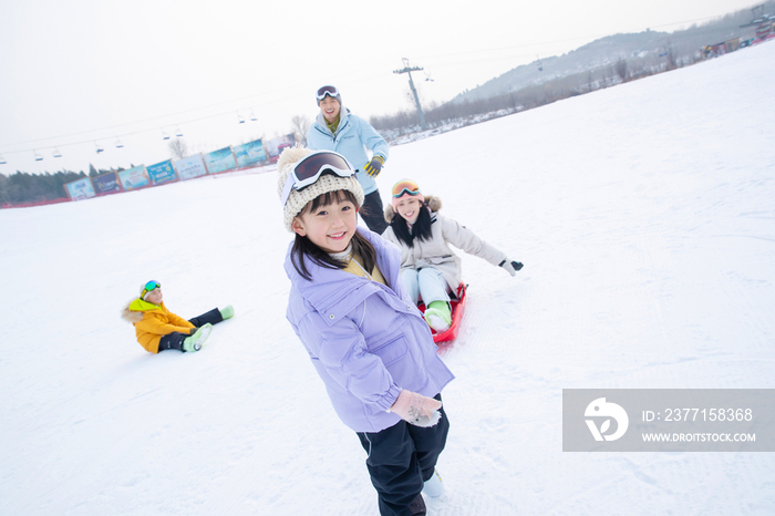 雪场上玩雪上滑板的一家四口