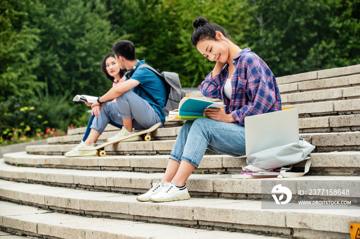 快乐的大学生坐在台阶上学习