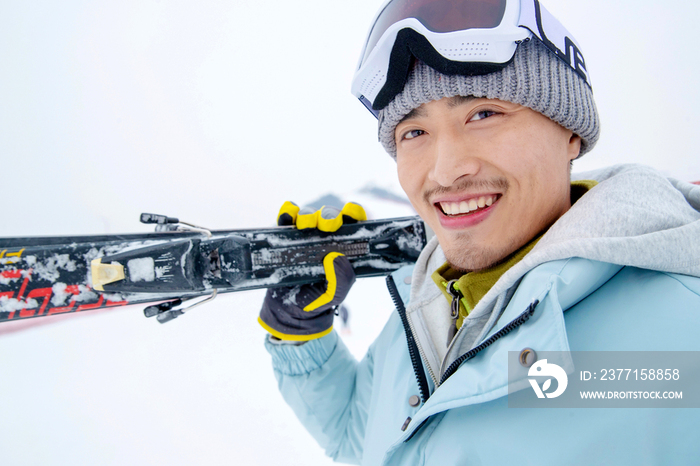 滑雪场上快乐的青年男人扛着滑雪板