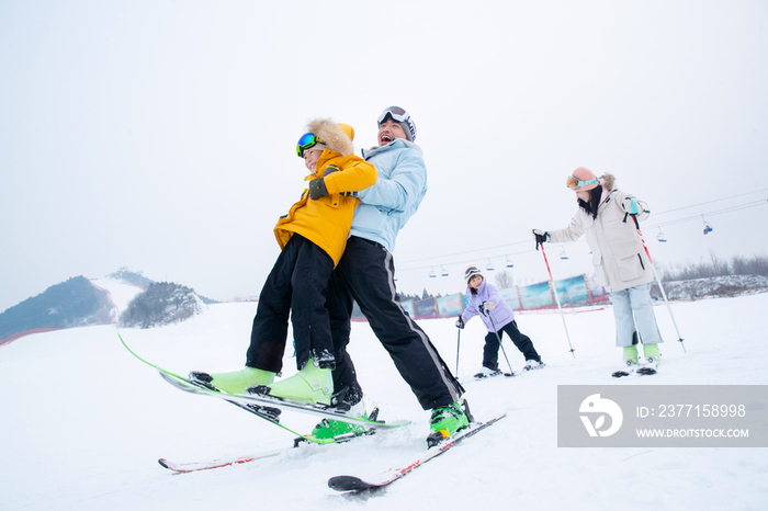 滑雪场内边滑雪边嬉戏的一家四口