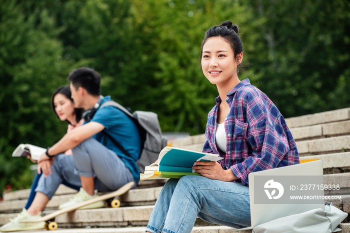 快乐的大学生坐在台阶上学习