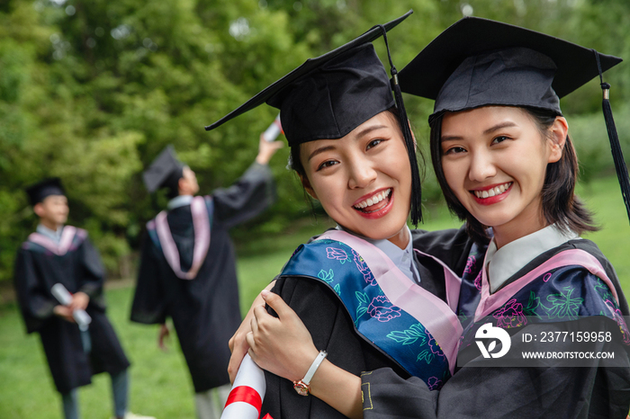 户外穿着学士服的大学生拥抱庆祝