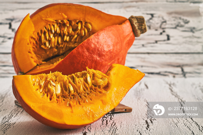 Red kuri squash (Hokkaido pumpkin) on white rustic wooden background