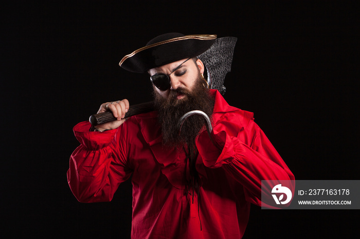 Thoughtful man in a pirate clothes for carnival with a hook insted of his hand