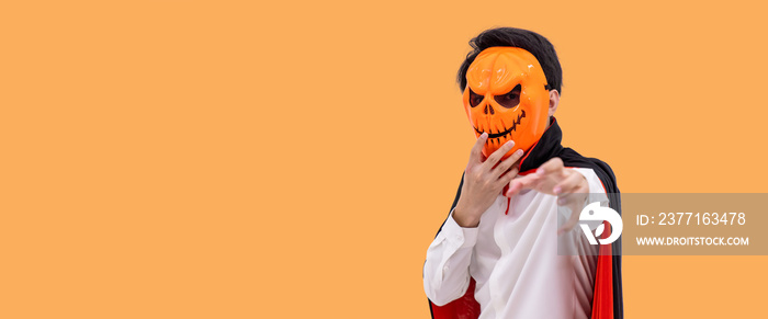 Asian man wearing Halloween costume as vampire Dracula on orange background, wearing pumpkin mask, l