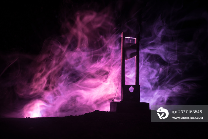 Horror view of Guillotine. Close-up of a guillotine on a dark foggy background.