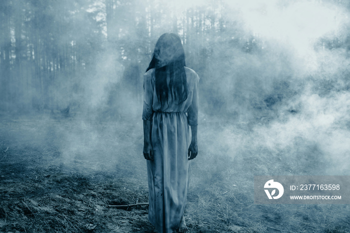 Girl in image of scary zombie walks in dark forest among smoke.