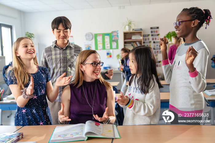 教师辅导小学生在教室里学习