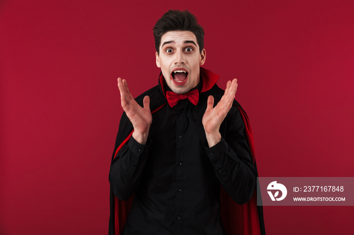 Image of excited vampire man with fangs in black halloween costume