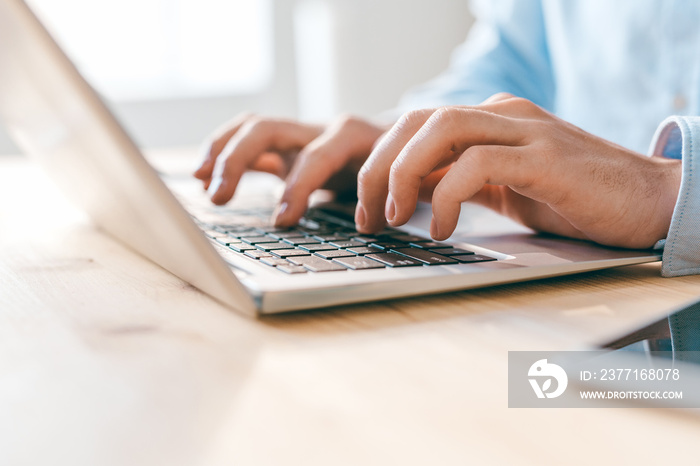 Hands of young businessman or analyst pressing keys of laptop keypad