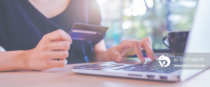 Business women hand use credit cards and laptop computers to shop online.