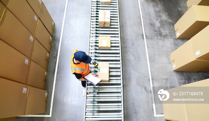 Workers in a mail order company scan packages for shipping // Arbeiter in einem Versandhandel scannt