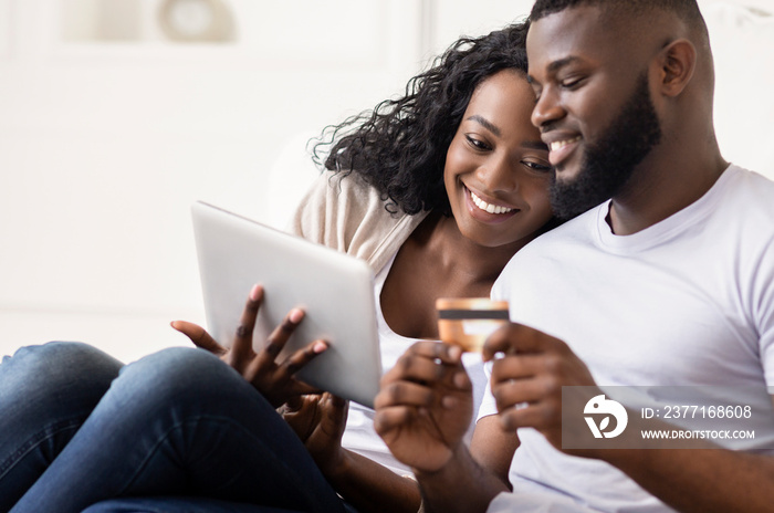 African American Couple Shopping Online Using Digital Tablet At Home