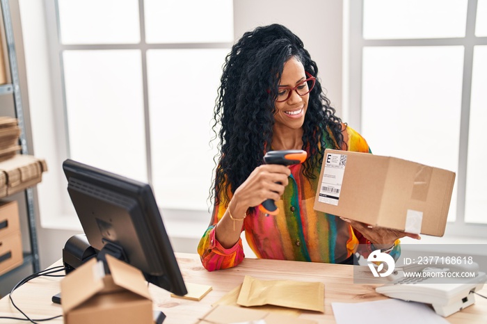 African american woman business worker scanning package at office