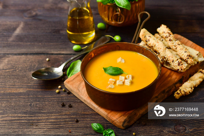 pumpkin soup and bread with basil and crispy crackers, vegan recipe. Autumn cream soup of seasonal p