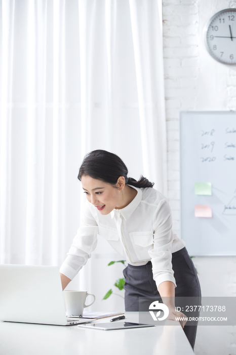 青年商务女人使用笔记本电脑办公