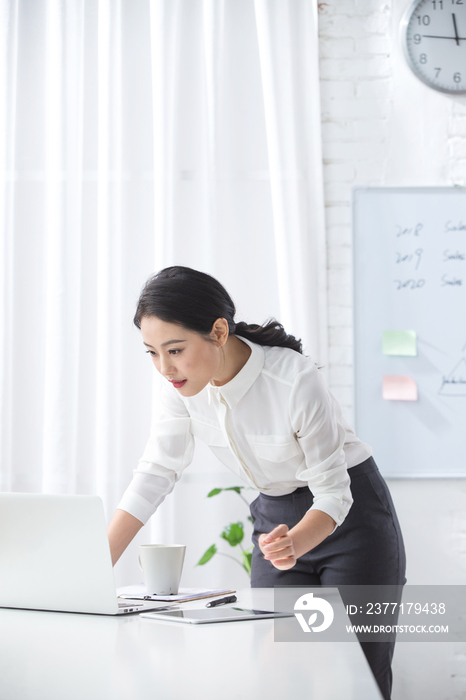 青年商务女人使用笔记本电脑办公