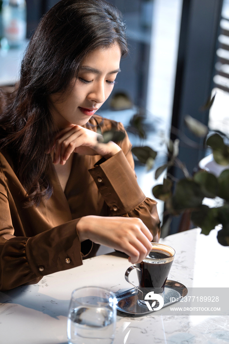 漂亮的青年女人喝咖啡