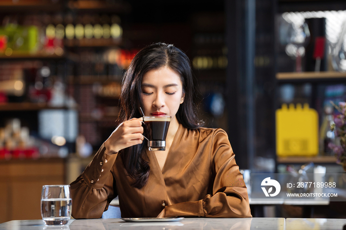 漂亮的青年女人喝咖啡