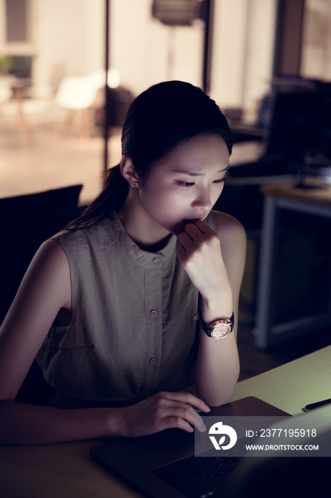 在办公室加班的年轻女士