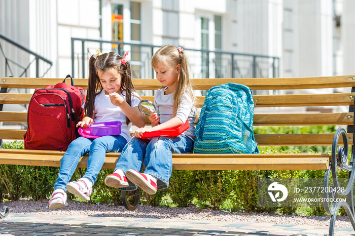 Elementary school kids sitting with packed lunches