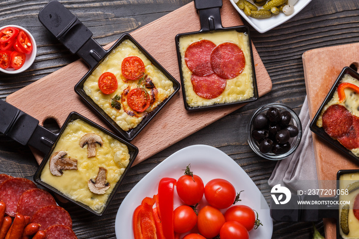 young woman is preparing a traditional Swiss cheese raclette