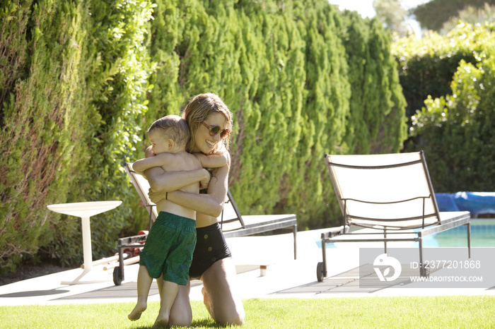 Mother embracing son at poolside