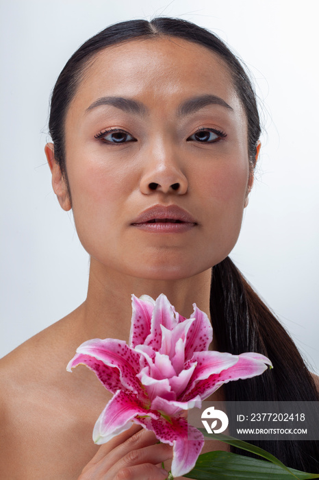 Studio portrait of woman with purple lily flower