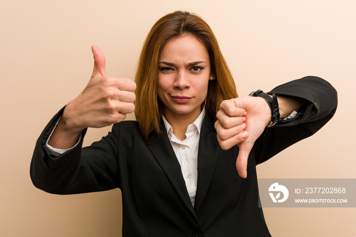 Young caucasian business woman showing thumbs up and thumbs down, difficult choose concept