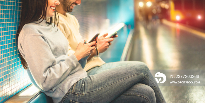 年轻的一对朋友在地铁站内使用手机——千禧一代有