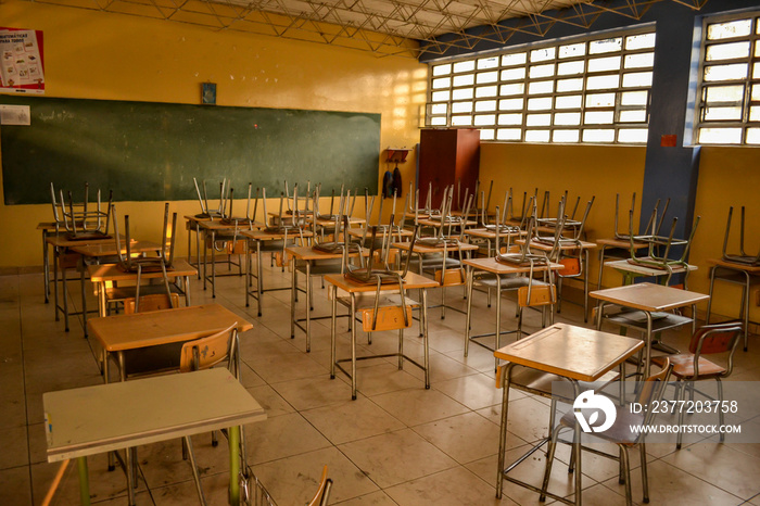 Chairs above desks in an empty classroom of a public school during quarantine.