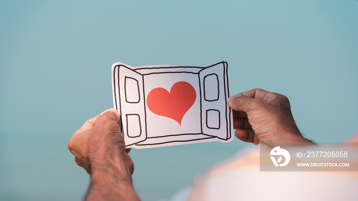 Mens hands holding paper cut of heart in window, encouragement,world mental health day,sharing,orga