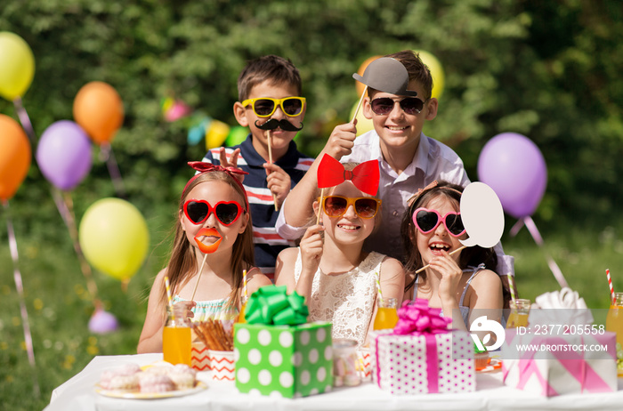 节日、童年和庆祝概念-快乐的孩子们在夏天生日时拥有派对道具