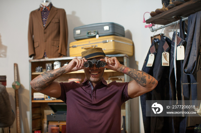 Young man looking through antique binoculars