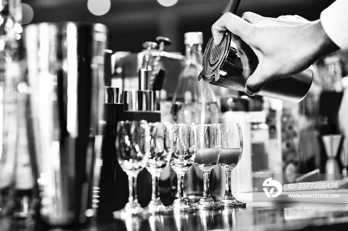 Bartender making alcohol cocktail at bar counter at nightclub, barman is making cocktail