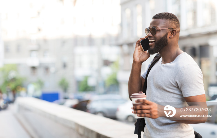 Young smiling african guy waiting for his friends in the city