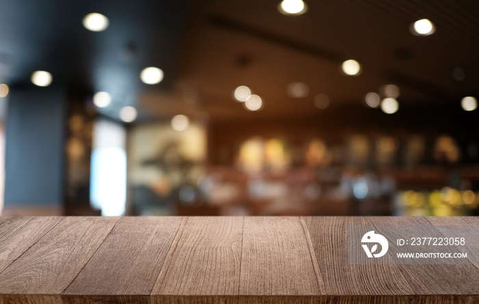 Empty dark wooden table in front of abstract blurred bokeh background of restaurant . can be used fo